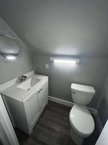a bathroom with a toilet sink and mirror