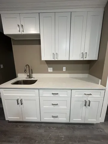 a kitchen with white cabinets and sink