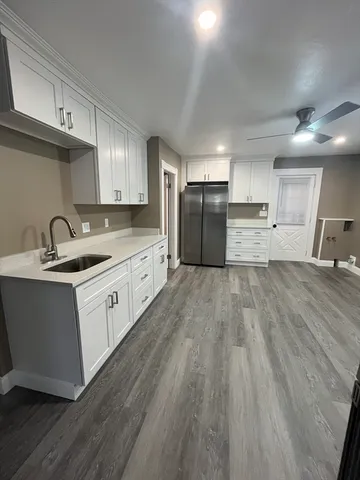 a kitchen with granite countertop a sink appliances and cabinets