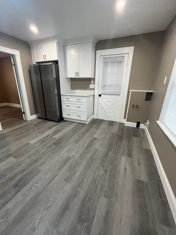 a view of a kitchen with wooden floor and electronic appliances