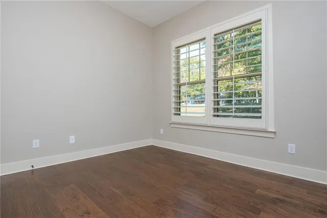 an empty room with windows and cabinet