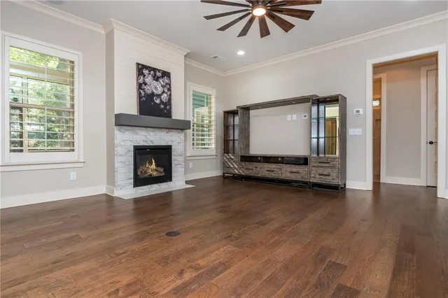 a view of a livingroom with wooden floor a ceiling fan and a window