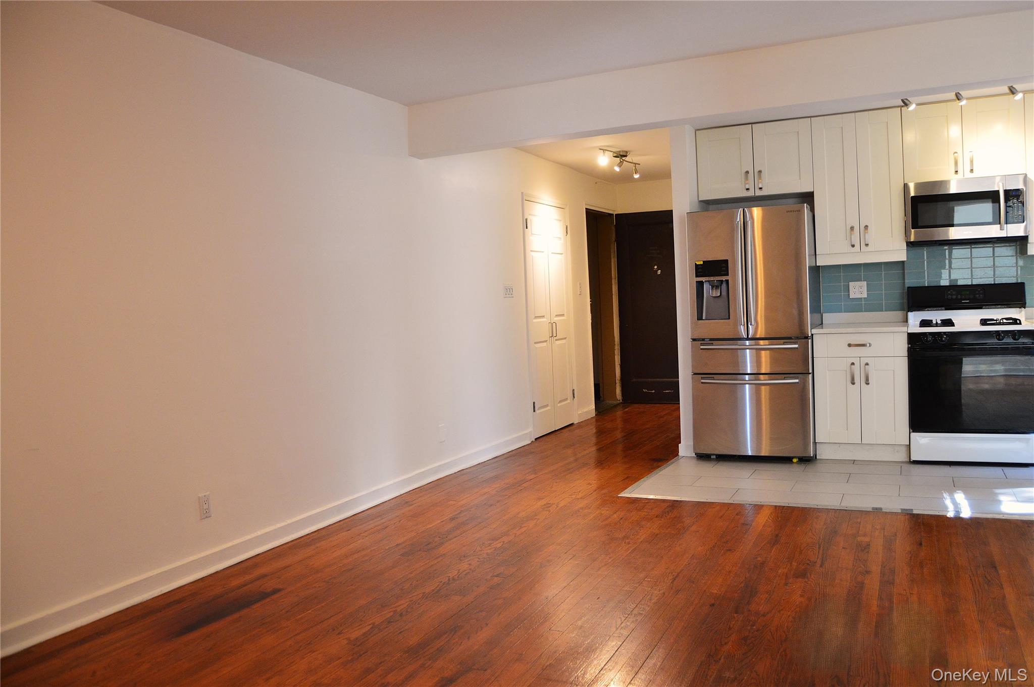 65-45 Yellowstone Boulevard, Unit 2B Queens, NY 11375 - Photo 3 of 14 a view of a kitchen with wooden floor and electronic appliances