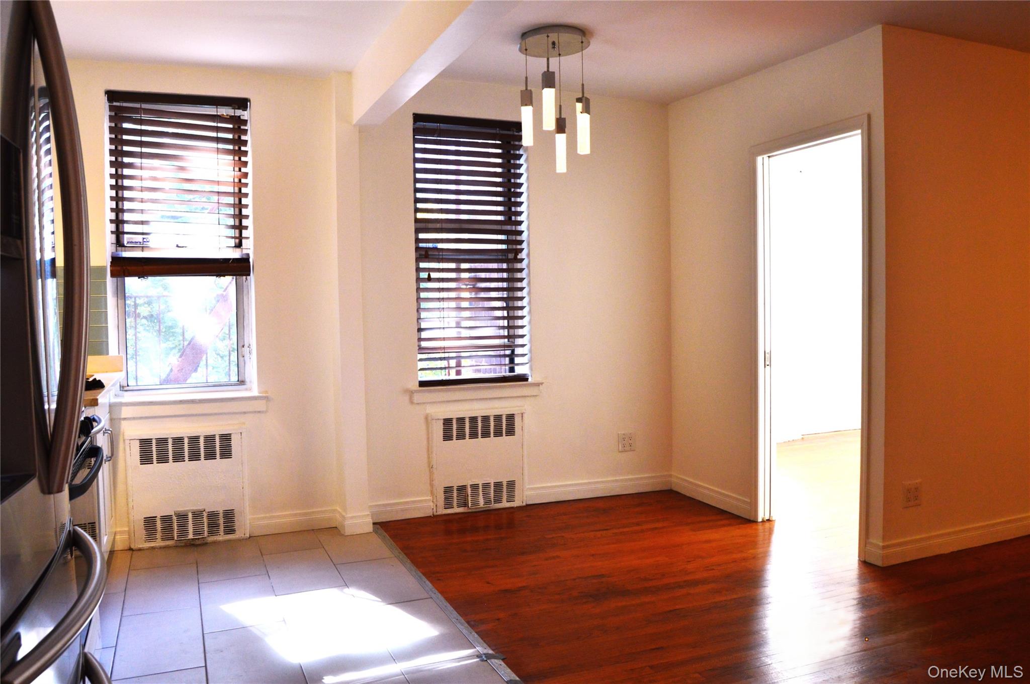 65-45 Yellowstone Boulevard, Unit 2B Queens, NY 11375 - Photo 5 of 14 a view of an empty room with a window and wooden floor