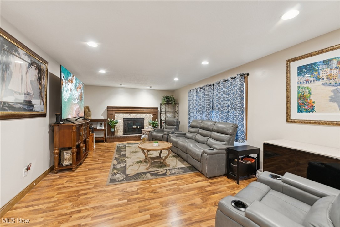 6930 Firestone Road Northeast Canton, OH 44721 - Photo 8 of 49 Family room featuring light wood-style floors, recessed lighting, and a glass covered fireplace