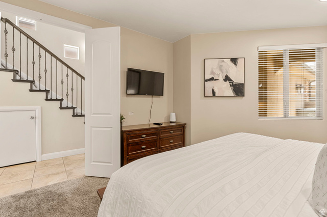 4257 Razor Drive Washington, UT 84780 - Photo 18 of 58 Room featuring a staircase with wrought iron balusters, a built-in storage area under the stairs, tile flooring, and a window with horizontal blinds
