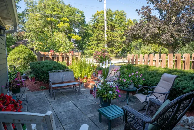a view of a chairs and table in the backyard of a house