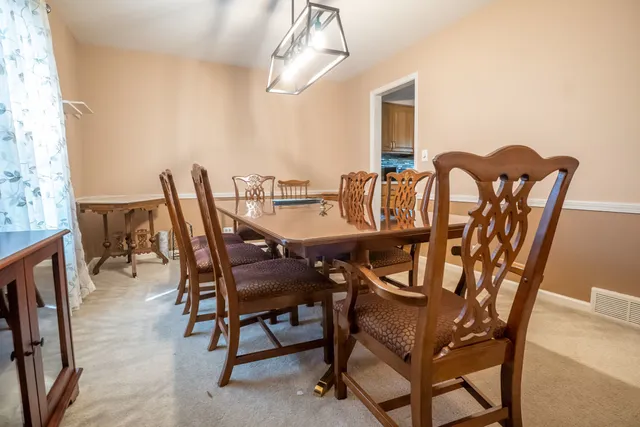 a view of a dining room with furniture and chandelier