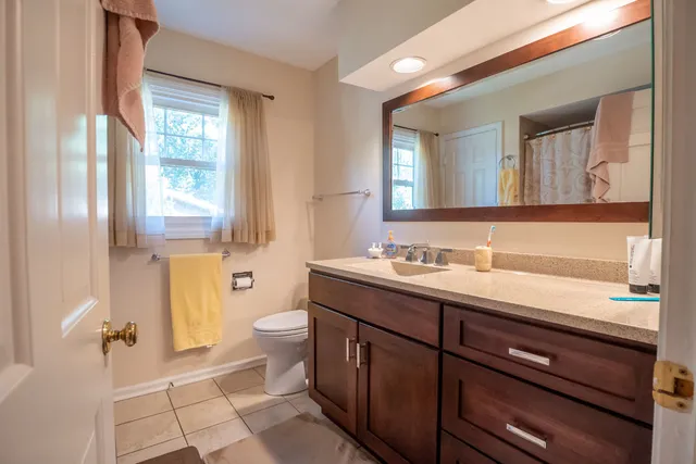 a bathroom with a double vanity sink toilet and a mirror