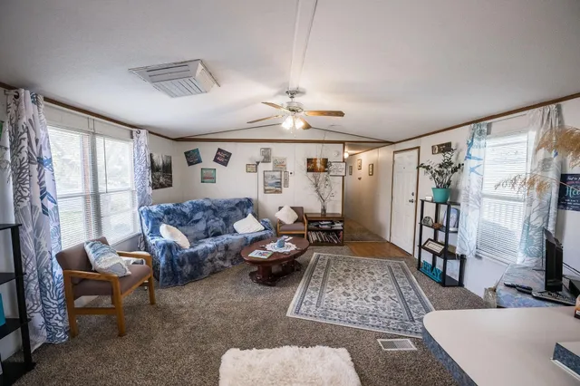 a living room with furniture ceiling fan and a window