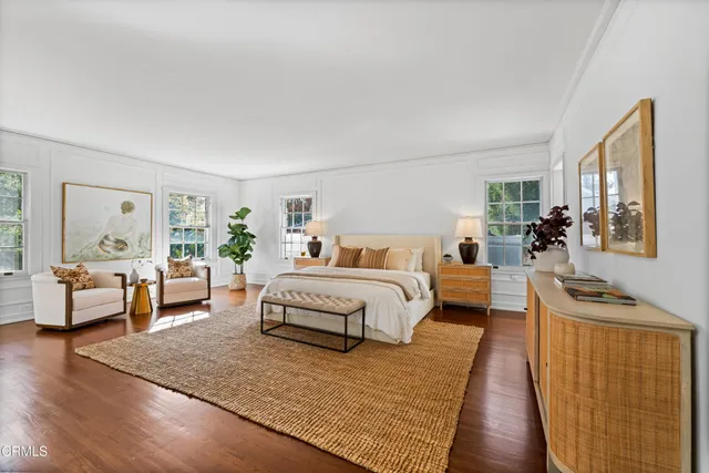 a spacious bedroom with a bed a couch and dresser