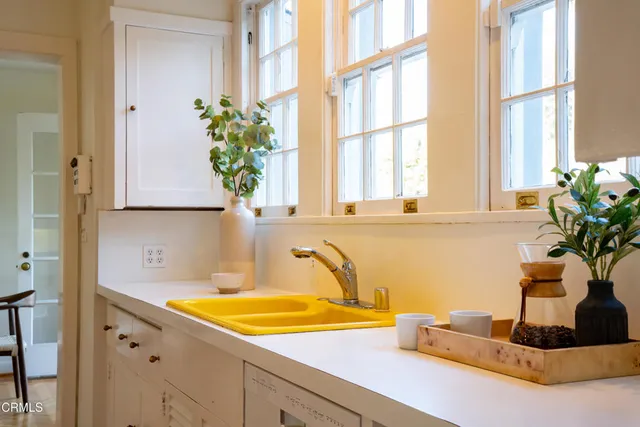 a bathroom with a granite countertop sink a potted plant and a window
