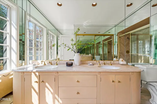 a bathroom with a granite countertop sink mirror and window
