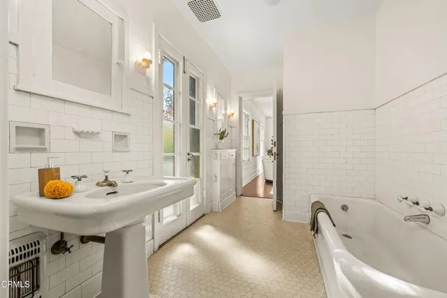 a bathroom with a tub sink and mirror