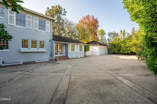 a view of an house with backyard and bushes