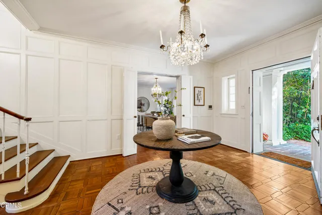 a view of a livingroom with furniture a chandelier windows and wooden floor
