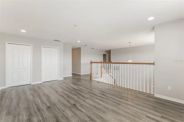 a view of an empty room with wooden floor