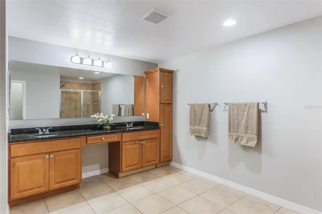 a large bathroom with a granite countertop sink and a mirror