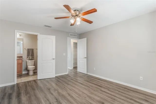 an empty room with closet and a ceiling fan