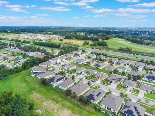an aerial view of residential houses with outdoor space and street view