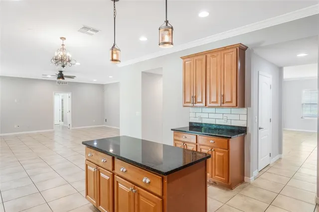 a kitchen with granite countertop a sink a counter space and cabinets