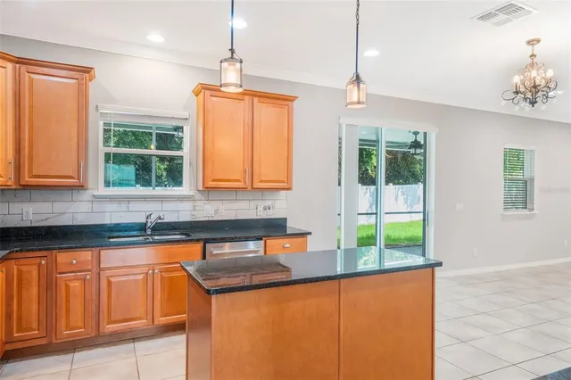 a kitchen that has a sink a window and cabinets