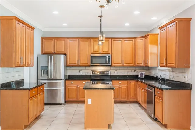 a kitchen with stainless steel appliances granite countertop a stove a sink dishwasher a refrigerator and cabinets