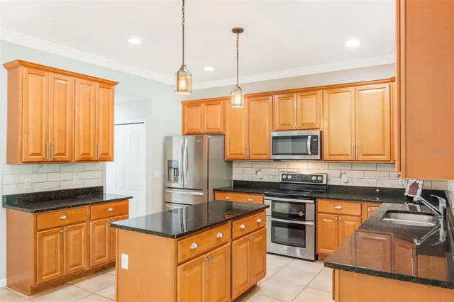a kitchen with stainless steel appliances granite countertop a sink stove and refrigerator