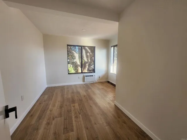 an empty room with windows and closet