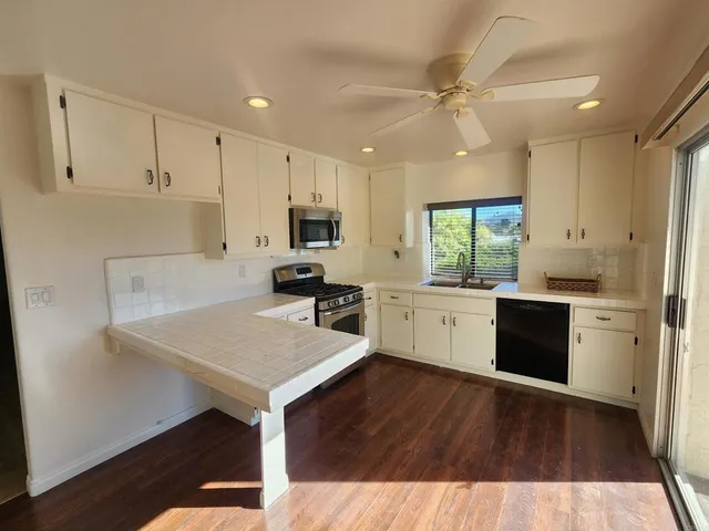 a kitchen with a sink cabinets stainless steel appliances and window
