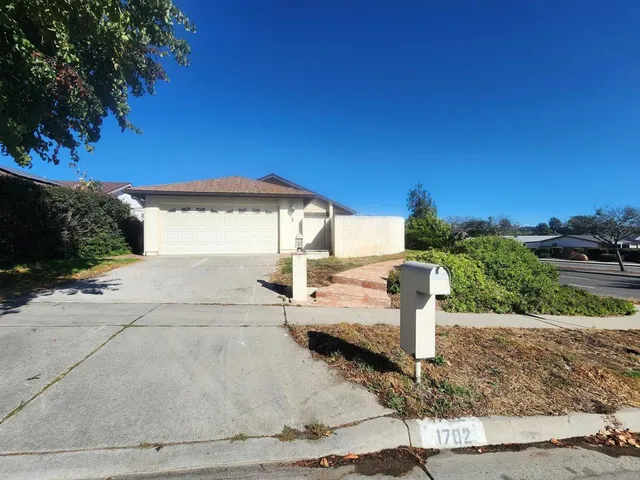 a view of a patio with a table and chairs under an umbrella