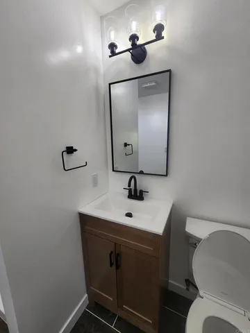 a bathroom with a toilet sink and mirror