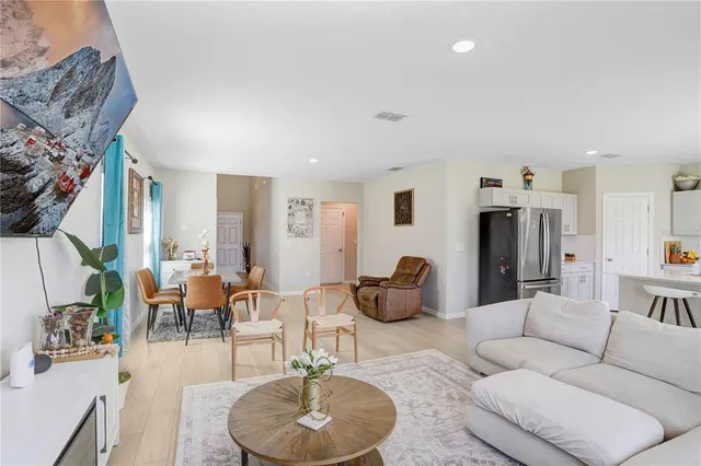 a living room with furniture kitchen view and a chandelier