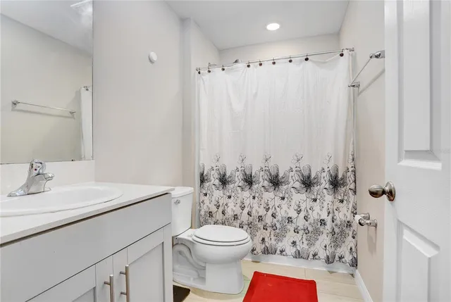 a bathroom with a sink a toilet and shower curtain