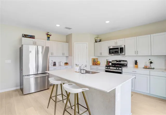 a kitchen with stainless steel appliances a refrigerator stove microwave and cabinets