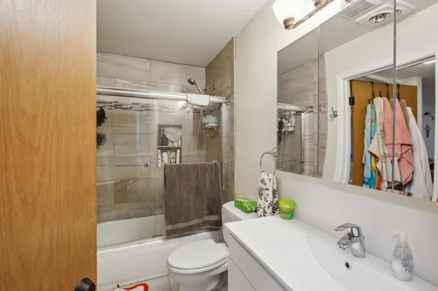 a kitchen with a refrigerator a stove a sink and a dining table with wooden floor