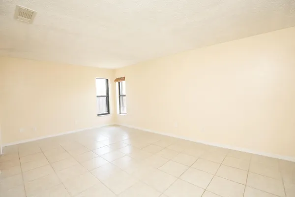 an empty room with windows and closet