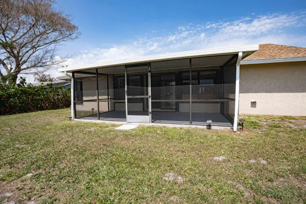 a front view of house with yard and trees in the background