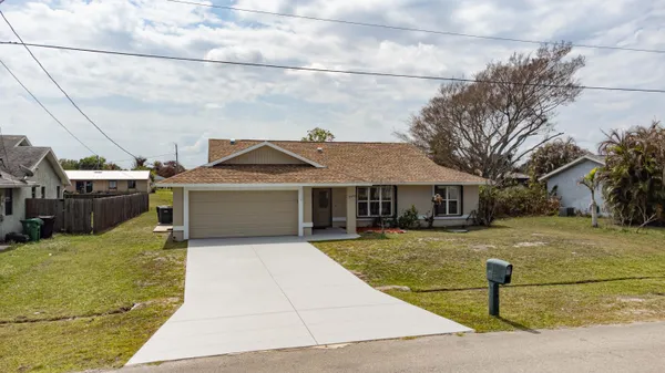 a view of a house with pool and a yard