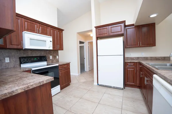 a kitchen with stainless steel appliances granite countertop a refrigerator and a stove
