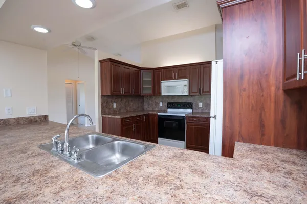 a view of a kitchen with kitchen island granite countertop a living room