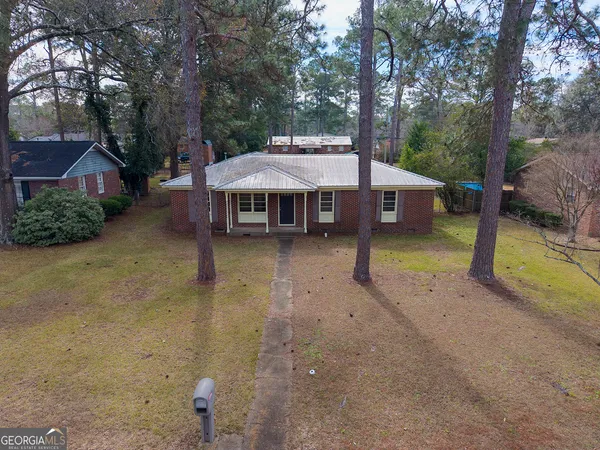 a view of a house with backyard and sitting area