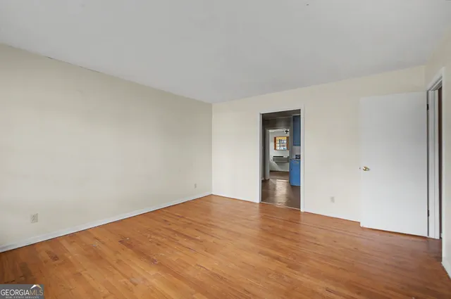 a view of empty room with wooden floor