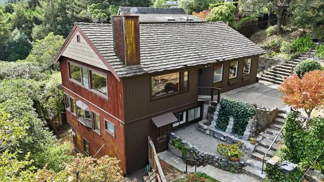 a aerial view of a house with balcony and trees