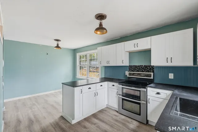 a kitchen with granite countertop a stove and a sink