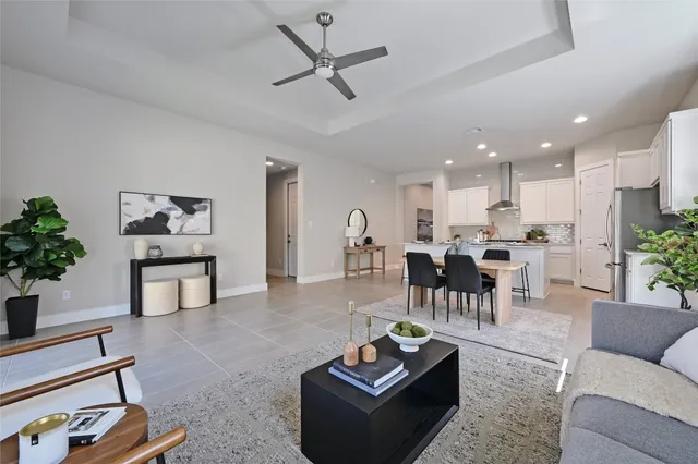 a living room with furniture kitchen view and a potted plant