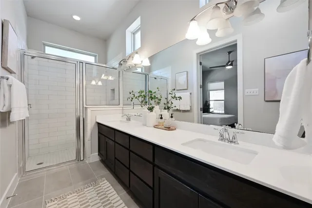 a bathroom with a double vanity sink mirror and shower
