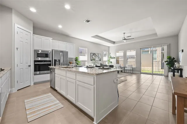 a kitchen with stainless steel appliances kitchen island granite countertop a refrigerator and microwave