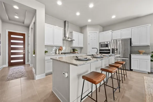 a kitchen with white cabinets and refrigerator