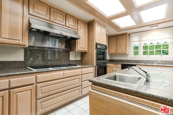 a kitchen with granite countertop white cabinets and a sink